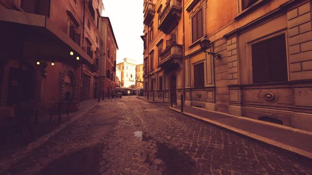 sunlit narrow lane with warm highlights on aged facades and damp cobbles, empty residential quarter suggesting morning routines, local character and quiet
