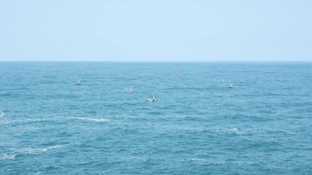 Traditional fishing boats floating on open blue ocean water.