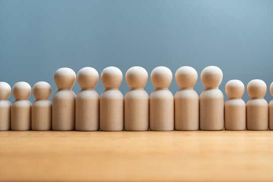 Wooden peg dolls representing hierarchy, diversity, and growth in business and society