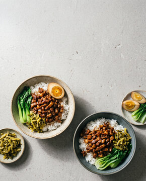 Taiwanese lu rou fan braised pork rice bowls with egg, top view with copy space, vertical