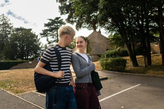 Two friends walking across a school parking lot