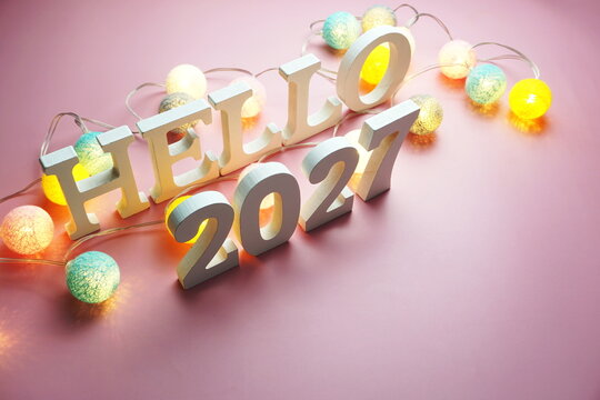 Hello 2027 alphabet letter with cotton ball LED decoration on pink background