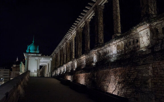 Night view along the illuminated terraces, colonnades and vine-covered retaining walls of the historic Varkert Bazar beneath Buda Castle in Budapest, Hungary.