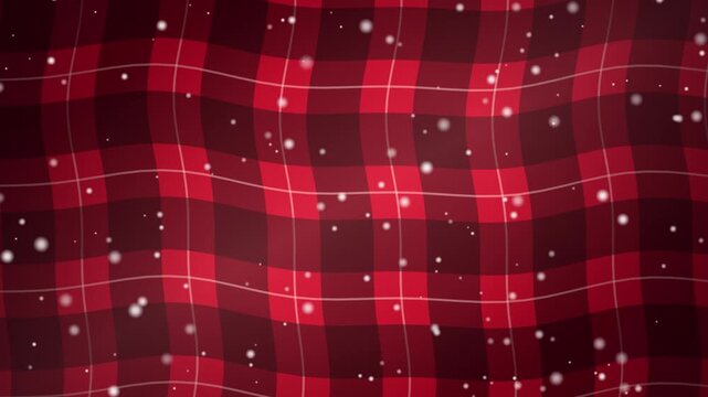 Falling snow over a red and black plaid fabric background