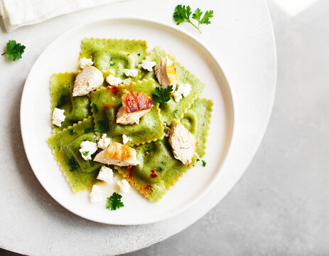 Spinach ravioli with tender chicken and cheese, top view. AI