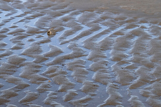 Water in the sand on a beach in Homer, Alaska