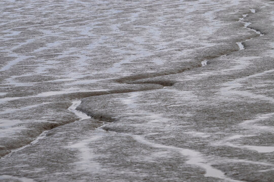 Water in the sand on a beach in Homer, Alaska