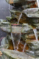 A multi-tiered decorative fountain with a cascading stone effect and LED lighting © mikus