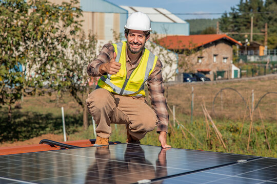 Solar engineer giving thumbs up installing photovoltaic panels