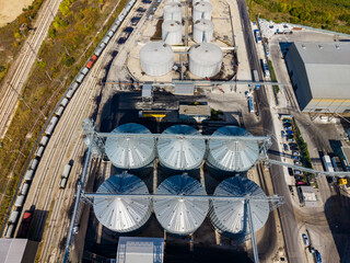 Aerial view of grain storage silos and rail cars at an industrial terminal in daylight © DSMT