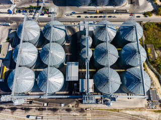Aerial view of grain silos and conveyor equipment at an industrial storage facility during the day © DSMT