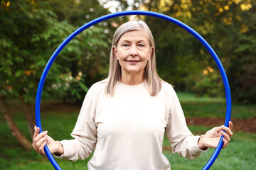 Senior woman with hula hoop in park © New Africa