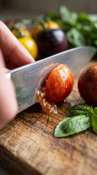 Chef Cutting Juicy Ripe Cherry Tomato On Cutting Board