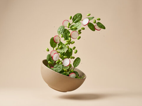 Fresh Green Salad Leaves And Radishes Levitating From Bowl