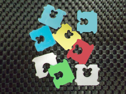Colorful Plastic Bread Bag Clips on a Dark Woven Background