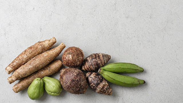 Tropical root vegetables cassava taro chayote and plantain flat lay