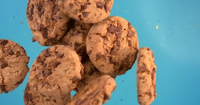 Chocolate chip cookies falling in slow motion 1000 fps on blue background