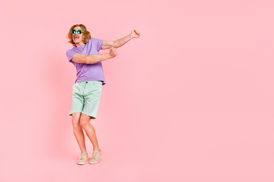Full length body size view of attractive cheerful comic guy dancing having fun rest isolated over pink pastel color background