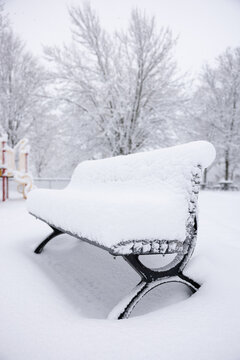 Banc de parc sous la neige qui tombe, jour, hiver, ext&eacute;rieur, vertical
