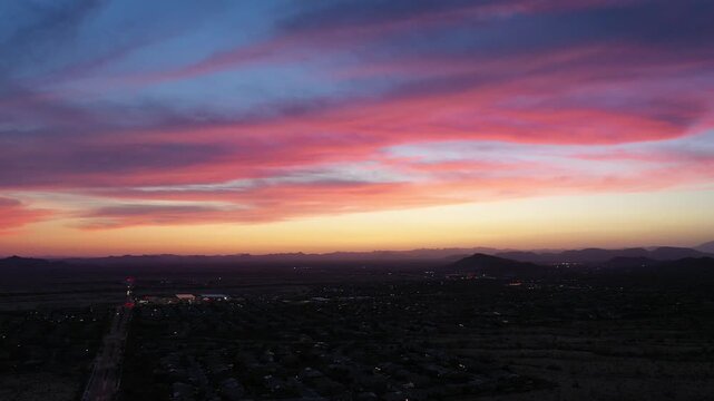 Aerial view of suburban landscape at sunset with vibrant colorful clouds