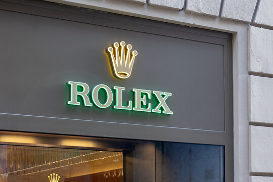 Luxury watch boutique storefront with illuminated crown emblem in rome
