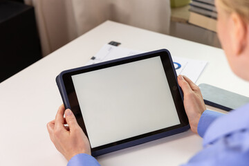 Tablet mock up with blank white screen held above a desk at home. white screen device isolated screen communication empty space frame mockup, internet touchpad inform © Kateryna Muzhevska