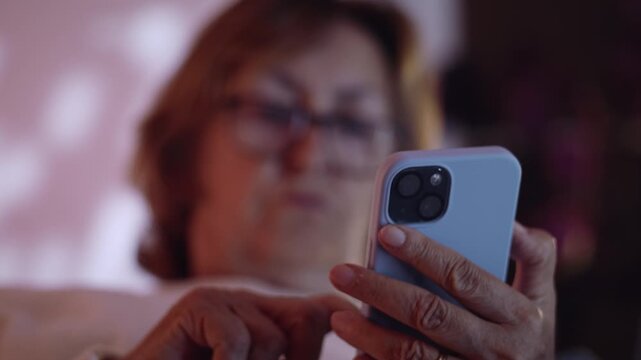Caucasian senior woman typing on her phone and reading the screen