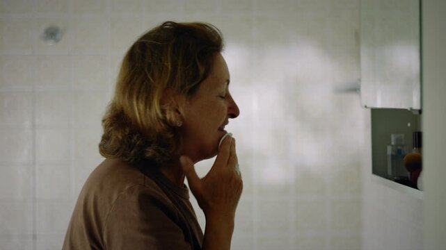 Elderly Caucasian woman cleansing her face with a cotton pad