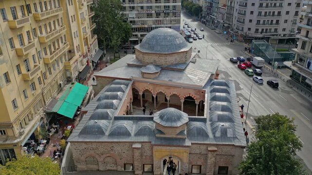  Cinematic 16:9 aerial video, shot in smooth 60fps, ascending over the restored Hamza Bey Mosque, also known as Alkazar, in Thessaloniki.