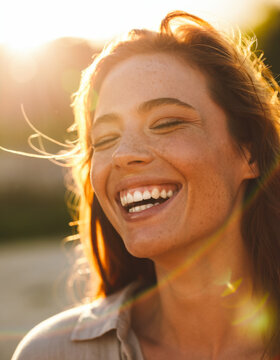 A beautiful model laughs at sunset.