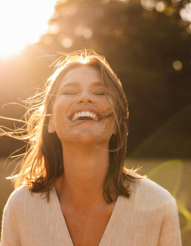A beautiful model laughs at sunset.