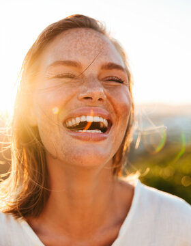A beautiful model laughs at sunset.