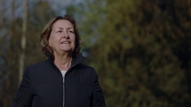 Happy Caucasian senior woman smiling and looking up at the sky
