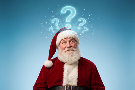 Thoughtful senior Santa Claus looking up at glowing holographic question marks above his head on blue studio background, showcasing concept of Christmas questions, curiosity, doubt, FAQ and holiday 