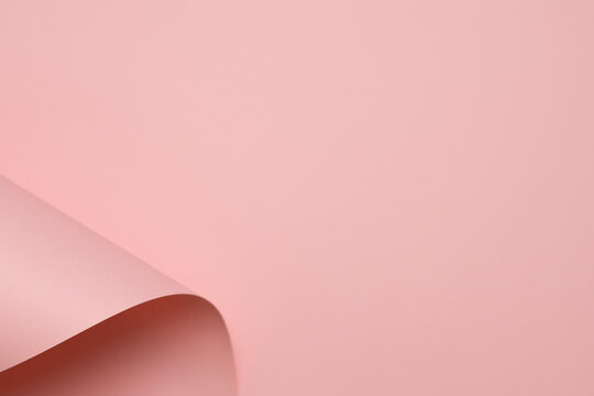 Abstract pastel pink paper background with curved shapes and soft shadows, minimalist geometric design