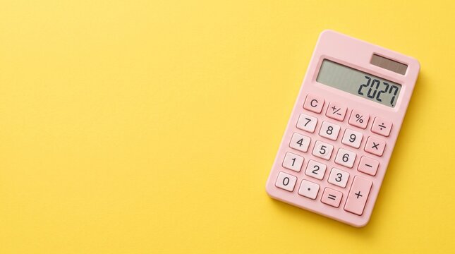 Pink calculator displaying 2027 on bright yellow background with copy space. Annual financial planning, budgeting, expense management, savings goals and personal or business finance preparation.