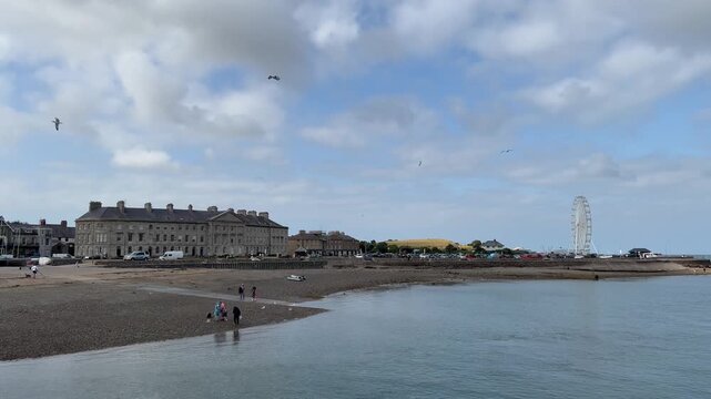 Anglesey, Wales, UK: Seaside town and waterfront at the edge of a calm Anglesey bay. This seaside footage suits travel, tourism and coastal recreation themes.