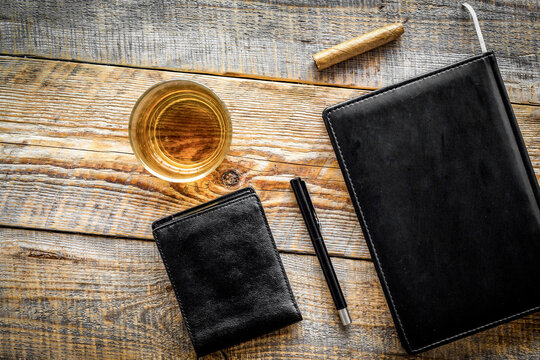 Drink whiskey in the evening. Glasses, wallet, cigar on rustic wooden background top view