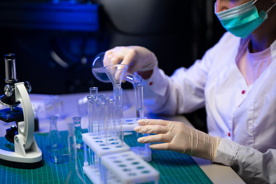 Close Up Of Scientist Hand Placing Test Tube In Rack During Vaccine Development Process