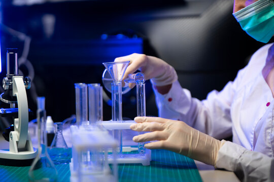 Researcher Placing Test Tube In Rack While Preparing Vaccine Samples In Medical Laboratory