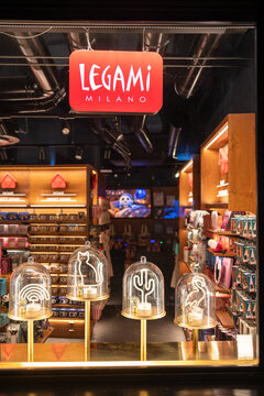 Illuminated Legami Milano store window at night with neon lamps under glass domes in Rome