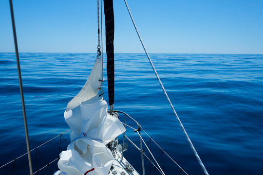 Sailing in Greece in the summer, View from the front of a yacht showing distant islands and the fore sail