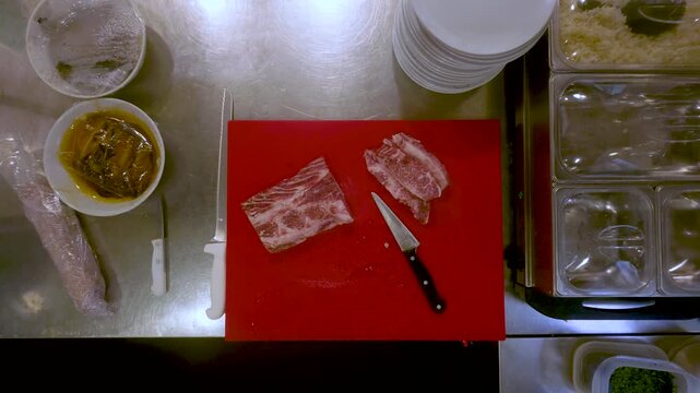 Raw Marbled Meat and Knife on a Red Cutting Board