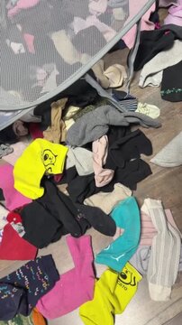 Pile of colorful mismatched socks on wooden floor