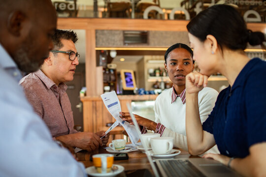 Coworkers reviewing a schedule over coffee in a cafe