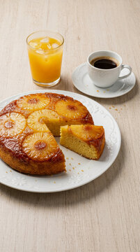 Bolo de abacaxi caramelizado invertido com uma fatia cortada no prato servido com x&iacute;cara de caf&eacute; preto e copo de suco de laranja natural - pineapple cake with caramel sauce