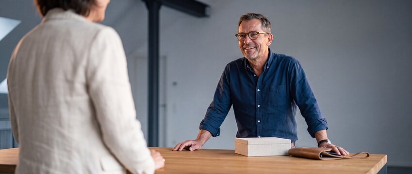 Immobilienarchitekt ber&auml;t Kundin voller Vertrauen im Neubau-Loft