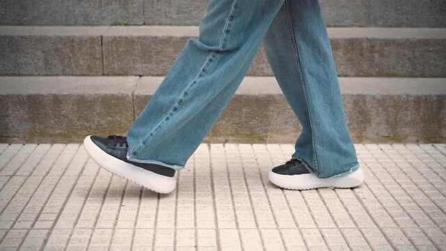 Close-up of an anonymous woman&rsquo;s feet walking outdoors. Concept of daily movement, outdoor activities, and an active urban lifestyle.
