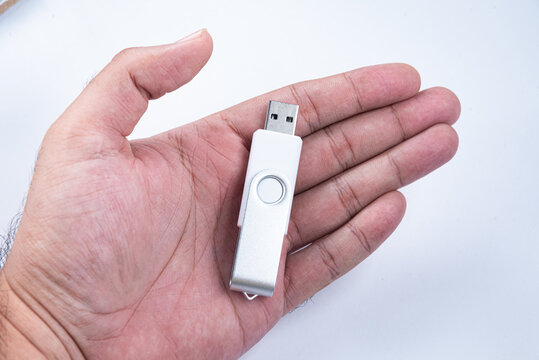 Hand holding a silver USB drive