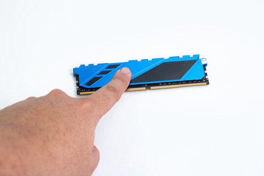 Finger touching a blue computer RAM module